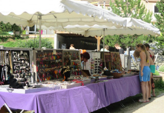Mercatino di gioielli all'aperto a Camping Le Gallo Romain, Auvergne-Rhône-Alpes, Francia, con visitatori.