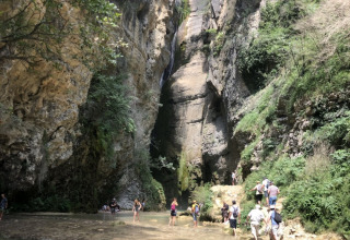 Folk nyder en flod og smukke klipper ved Camping Le Gallo Romain i Auvergne-Rhône-Alpes, Frankrig.