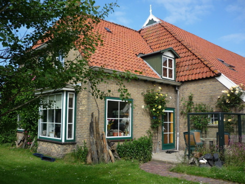 Encantadora casa de ladrillo con techo de tejas rojas y jardín en Feather Down De Zeekraal Terschelling, Frisia.