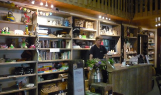 Indretning af Feather Down De Zeekraal Terschelling feriepark med træmøbler, bøger og en receptionsdisk.