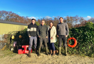 Vier Menschen stehen draußen bei Feather Down De Zeekraal Terschelling, einem Ferienpark in Friesland, Niederlande.