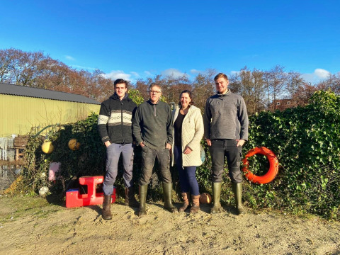 Four people stand outdoors at Feather Down De Zeekraal Terschelling, a holiday park in Friesland, Netherlands.