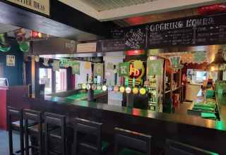 Barområde i Camp Diekirch feriepark i Diekirch, Luxembourg, dekoreret med grønne St. Patrick's Day bannere.