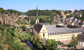 Vista panoramica di una chiesa, edifici storici e vegetazione vicino a un fiume nei pressi di Diekirch, Lussemburgo.