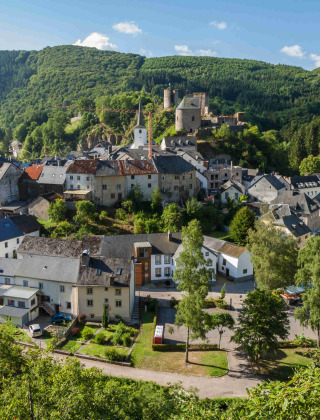 Vista panoramica di un incantevole villaggio e castello vicino a Diekirch, Lussemburgo, tra verdi colline.