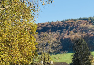 Reception at Camp Diekirch, Luxembourg, nestled in green hills with trees and clear blue autumn skies.