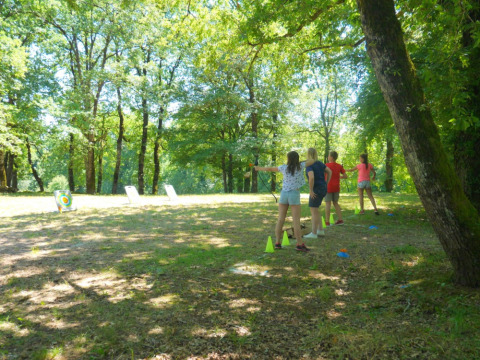 Niños practicando tiro con arco en el bosque de Camping lac Aux Oiseaux, un parque vacacional en Occitania, Francia.