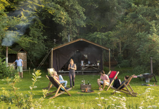 Gruppo rilassato davanti a una tenda a Feather Down Het Wesselink a Salland, parco vacanze in Overijssel.