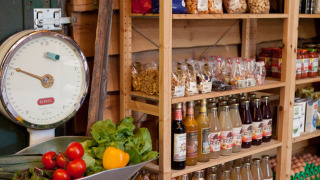 Épicerie de ferme avec légumes frais, balance ancienne, boissons en bouteille et snacks à Het Wesselink.