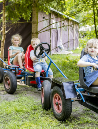 Niños montando karts a pedales en Feather Down Het Wesselink in Salland, parque vacacional en Overijssel, Países Bajos.
