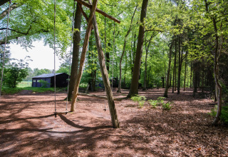 Legeplads med gynger i en skov ved Feather Down Het Wesselink in Salland, feriepark i Overijssel, Holland.