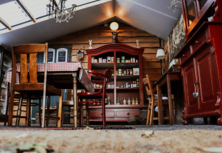 Zona pranzo rustica con mobili in legno e credenza rossa a Feather Down Het Wesselink, Overijssel, Paesi Bassi.