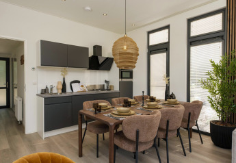Moderne Lodgeküche mit elegantem Essbereich für sechs Personen, großen Fenstern und viel Tageslicht.
