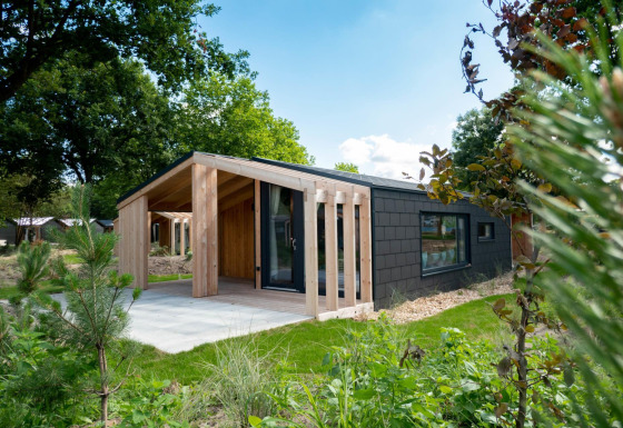 Chalet moderne en bois au Panorama Cottage, Kaatsheuvel, Pays-Bas, entouré de verdure et jardin.