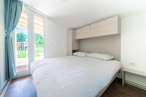 Dormitorio en Panorama Cottage en Kaatsheuvel, Países Bajos, con cama doble y vista al jardín.