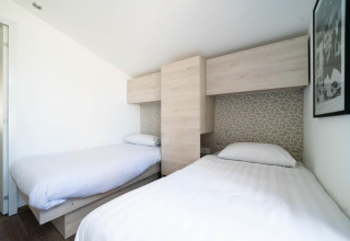Dos camas individuales en una habitación luminosa y moderna en Panorama Cottage, Kaatsheuvel, Países Bajos.