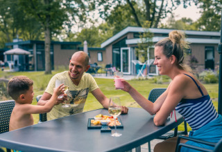 Familia disfruta de bebidas y bocadillos al aire libre en la cabaña Panorama Cottage en Kaatsheuvel, Países Bajos.