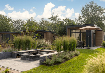 Lodge moderno Loevestein Deluxe en Veluwepark de Bosgraaf, Países Bajos, rodeado de preciosos jardines verdes.