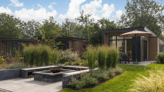 Moderne lodge Loevestein Deluxe på Veluwepark de Bosgraaf, Nederlandene, omgivet af frodige haver.
