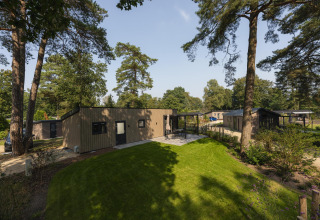 Afbeelding van Loevestein Deluxe lodge in Veluwepark de Bosgraaf, Nederland, in een groene bosrijke omgeving.