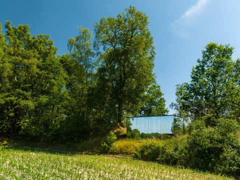 Spiegelende tiny house, ÖÖD Suite, verscholen tussen groene bomen in Wilsumer Berge, Duitsland.