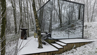 De ÖÖD Suite tiny house met spiegelwanden staat in een besneeuwd bos bij Wilsumer Berge, Duitsland.