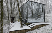 La pequeña casa ÖÖD Suite con paredes espejadas, en un claro nevado del bosque en Wilsumer Berge, Alemania.