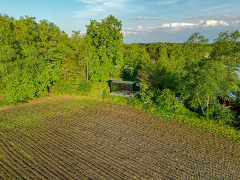 Luchtfoto van ÖÖD Suite tiny house bij Wilsumer Berge in Duitsland, omgeven door bomen en een akker.