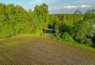 Luchtfoto van de ÖÖD Suite tiny house bij Wilsumer Berge in Duitsland, omgeven door bomen en veld.
