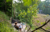 Vrouw ontspant op terras bij ÖÖD Suite in Wilsumer Berge, Duitsland, tussen het groene landschap.