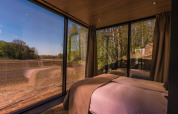 Vue d'une chambre à ÖÖD Suite tiny house à Wilsumer Berge, Allemagne, avec grandes baies vitrées.