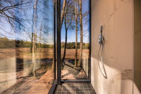 Moderne douche in de ÖÖD Suite met panoramisch boszicht bij Wilsumer Berge, Duitsland.