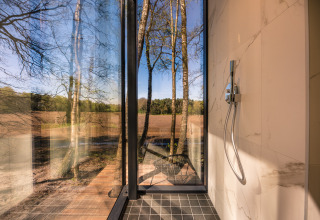 Moderne douche in de ÖÖD Suite met panoramisch boszicht bij Wilsumer Berge, Duitsland.