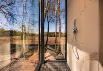 Moderne douche in de ÖÖD Suite met panoramisch boszicht bij Wilsumer Berge, Duitsland.