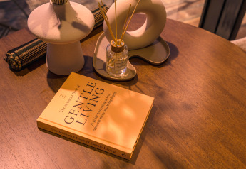 A cozy table at the ÖÖD Suite tiny house with 'Gentle Living' book and diffuser at Wilsumer Berge, Germany.