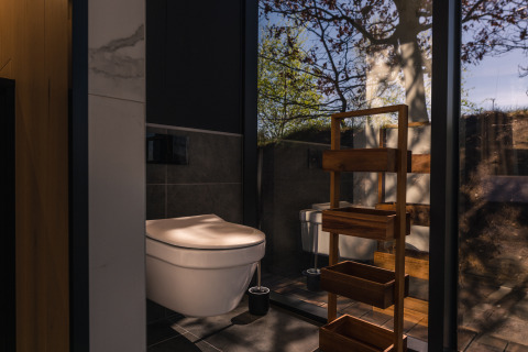 Bagno moderno nella tiny house ÖÖD Suite a Wilsumer Berge, Germania, con parete in vetro e vista sulla natura.