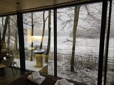Uitzicht vanuit de ÖÖD Suite tiny house bij Wilsumer Berge in Duitsland met sneeuw en bomen.