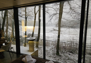 Uitzicht vanuit de ÖÖD Suite tiny house bij Wilsumer Berge in Duitsland met sneeuw en bomen.