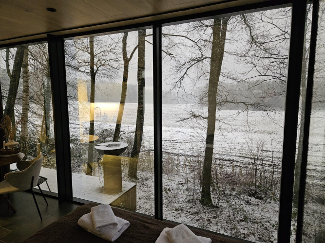 View from the ÖÖD Suite tiny house at Wilsumer Berge in Germany, showing snowy landscape and trees.