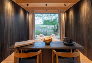 Moderne interiør i Nokken Forest Cabin med udsigt til naturen gennem stort vindue, Wilsumer Berge, Tyskland.