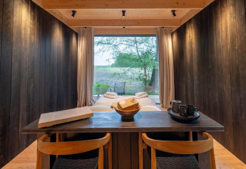 Moderne interiør i Nokken Forest Cabin med udsigt til naturen gennem stort vindue, Wilsumer Berge, Tyskland.