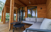 Moderne houten terras met comfortabele banken en tafels bij The Beach House in Wilsumer Berge, Duitsland.