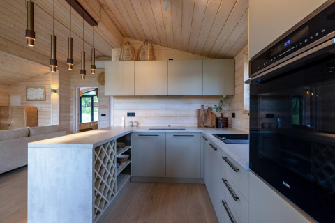 Intérieur de cuisine moderne au Beach House à Wilsumer Berge, Allemagne, avec bois clair et suspensions.
