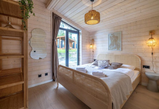 Acogedor dormitorio con paredes de madera y cama en The Beach House en Wilsumer Berge, Alemania.