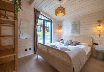 Hyggeligt soveværelse med trævægge, stor seng og vindue i The Beach House ved Wilsumer Berge, Tyskland.