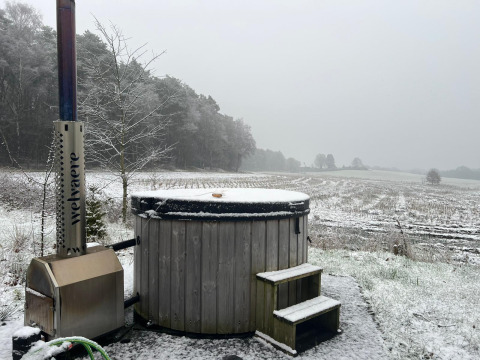Buiten hot tub met sneeuw bij Nature Lodge + Hot Tub, Wilsumer Berge, Duitsland, met landelijke uitzichten.
