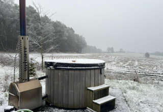 Udsigt over snedækket felt med et træbadekar og skorsten ved Nature Lodge + Hot Tub, Wilsumer Berge.