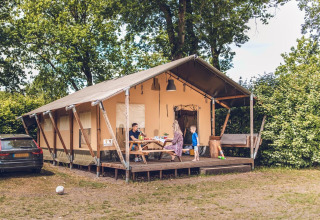 Familia disfruta al aire libre en una tienda safari en Veluwepark de Bosgraaf en los Países Bajos.