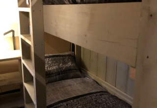 Habitación acogedora con literas en una tienda safari en Veluwepark de Bosgraaf, Países Bajos, con escritorio.