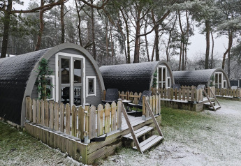 Petits chalets en bois avec terrasse sous la neige près de la forêt à Woodlodge, Wilsumer Berge, Allemagne.
